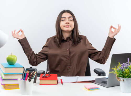 Mulher praticando meditação no trabalho para equilibrar a rotina profissional e pessoal.