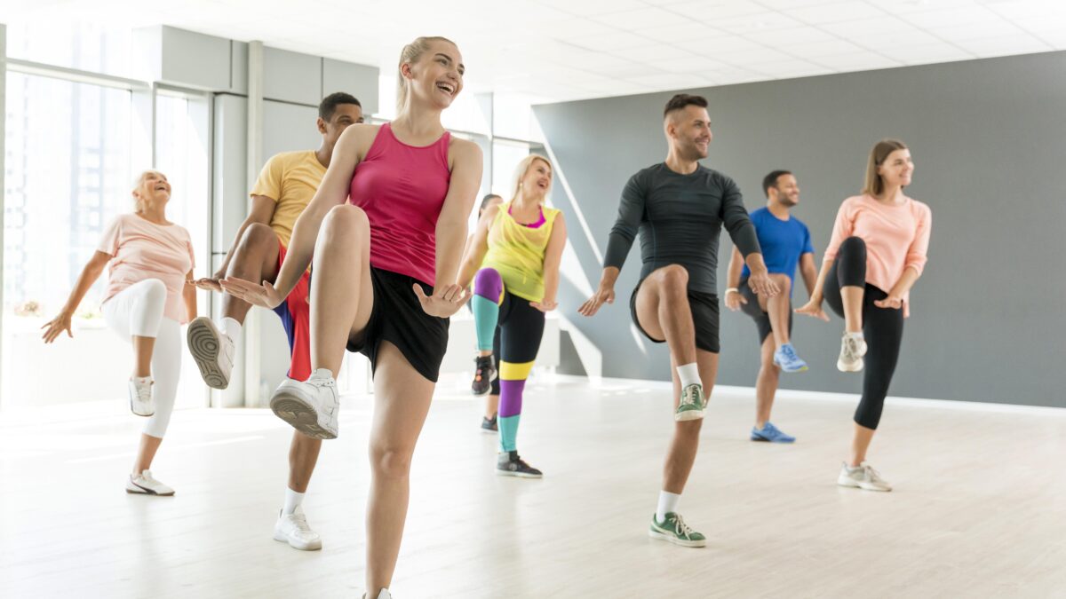 Pessoas se movimentando em uma aula de dança que estimula corpo e mente, reforçando os benefícios da dança para o cérebro.