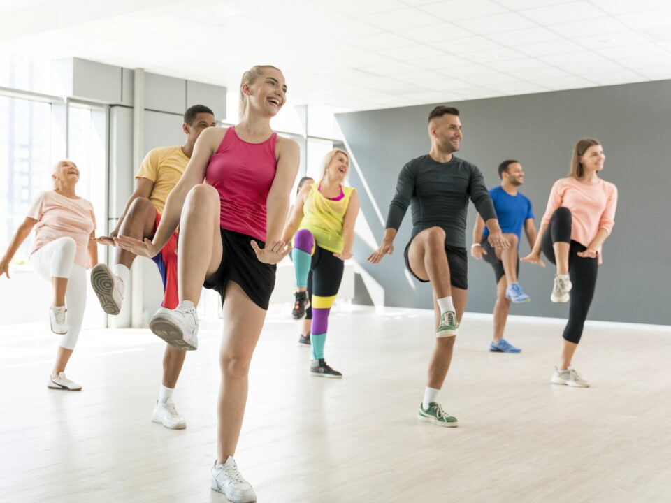 Pessoas se movimentando em uma aula de dança que estimula corpo e mente, reforçando os benefícios da dança para o cérebro.