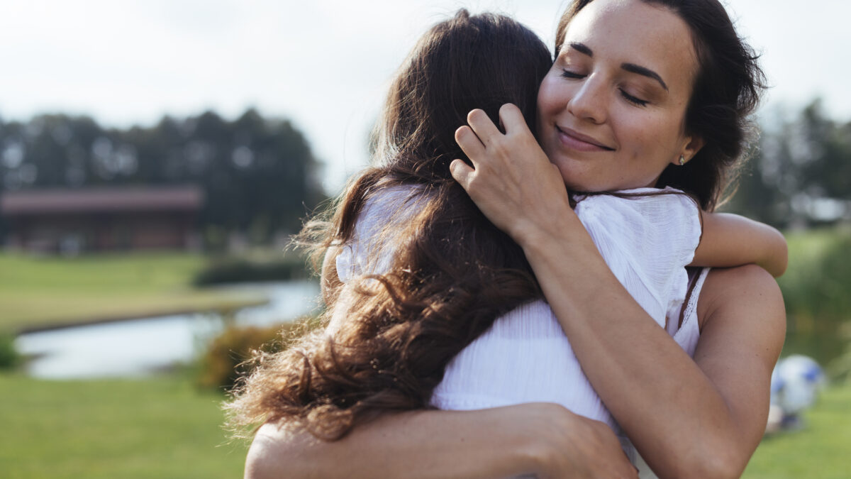 Ilustração do conceito de autocuidado e empatia: um abraço que representa cuidado mútuo e bem-estar emocional.