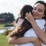 Ilustração do conceito de autocuidado e empatia: um abraço que representa cuidado mútuo e bem-estar emocional.