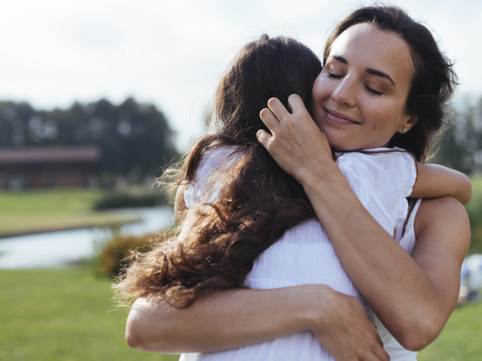 Ilustração do conceito de autocuidado e empatia: um abraço que representa cuidado mútuo e bem-estar emocional.