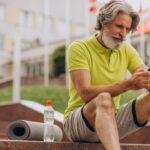 Homem de meia-idade descansando após atividade física ao ar livre, representando o exercício físico no controle do diabetes.
