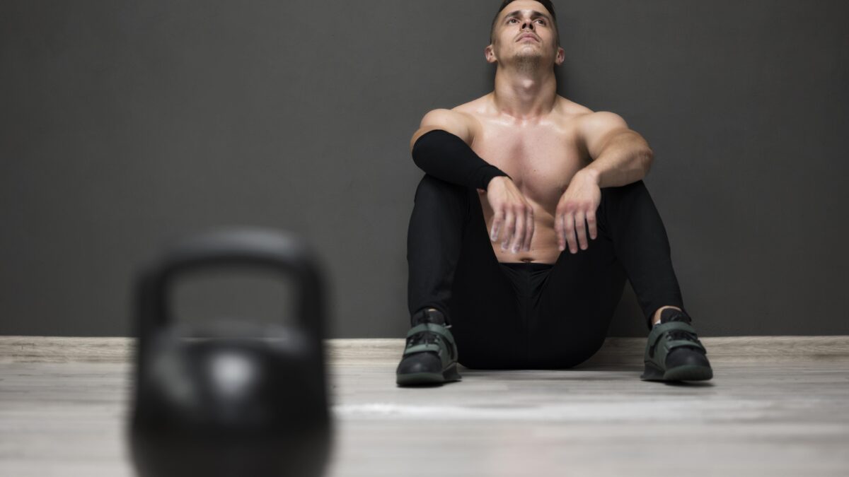 Homem descansando após o treino, pensando em desistir da academia em janeiro.