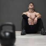 Homem descansando após o treino, pensando em desistir da academia em janeiro.